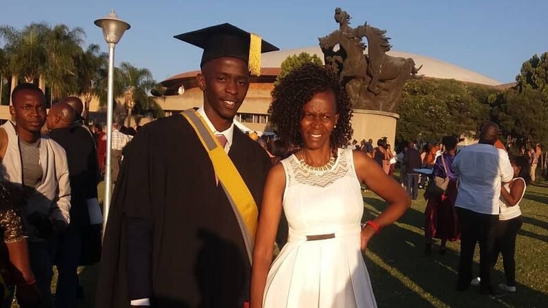 DYL alum Karabo stands in his graduation cap and gown